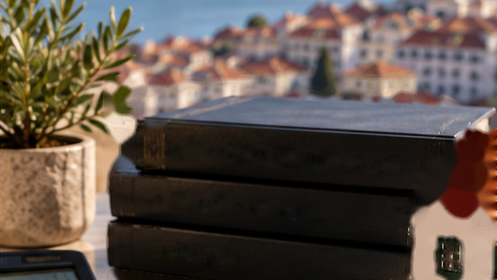 Lisbon office desk with neutral law books, a calculator and a model house, illustrating Portuguese inheritance tax.